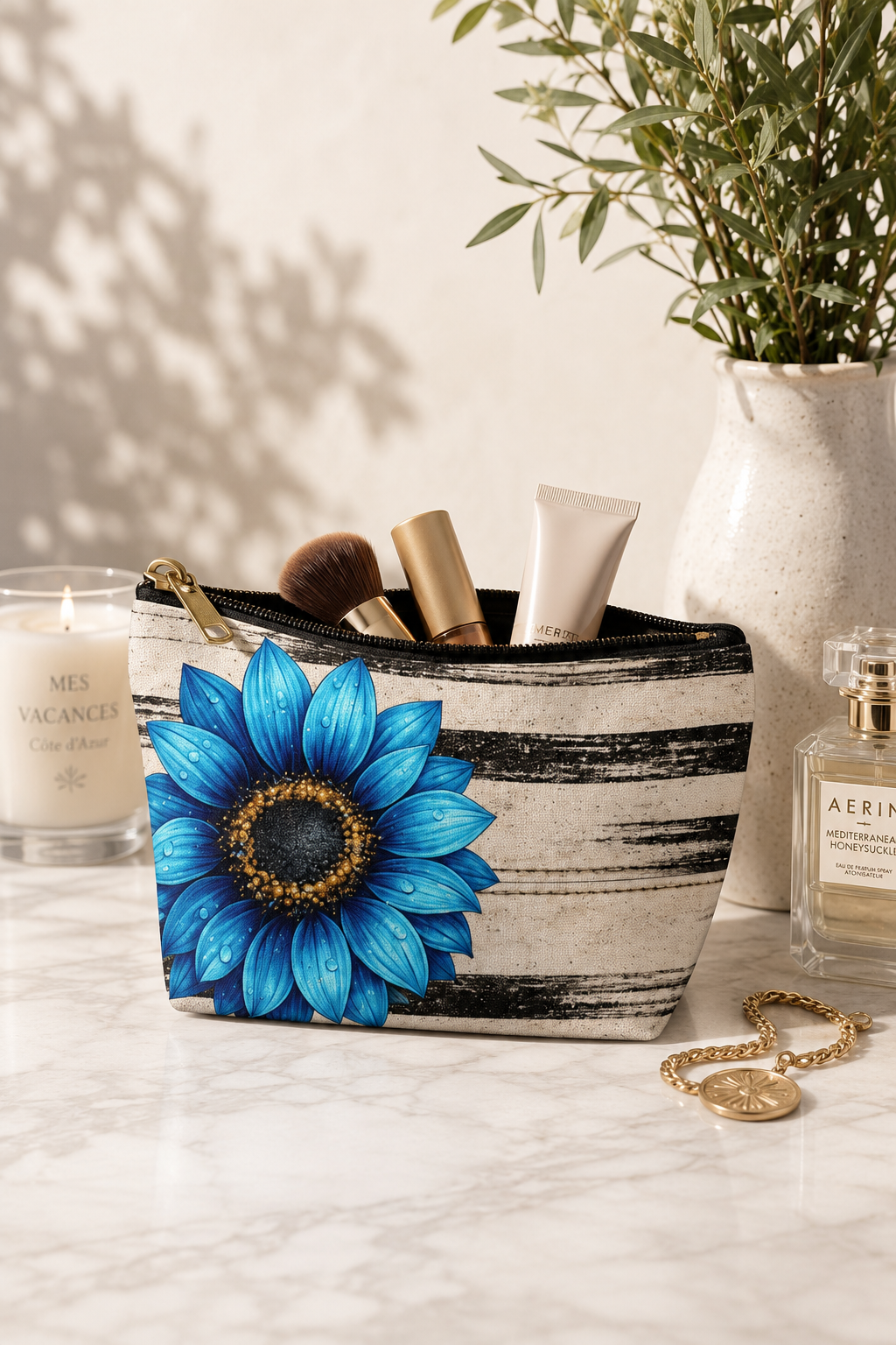 Boho Sunflower Makeup Bag standing upright on a vanity with black-and-beige vintage stripes, bright blue sunflower artwork, black zipper and makeup brushes inside.
